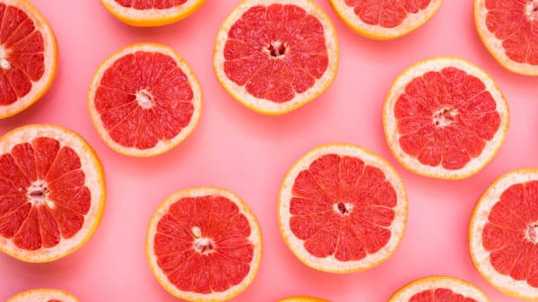 Grapefruit halves displayed on pink background